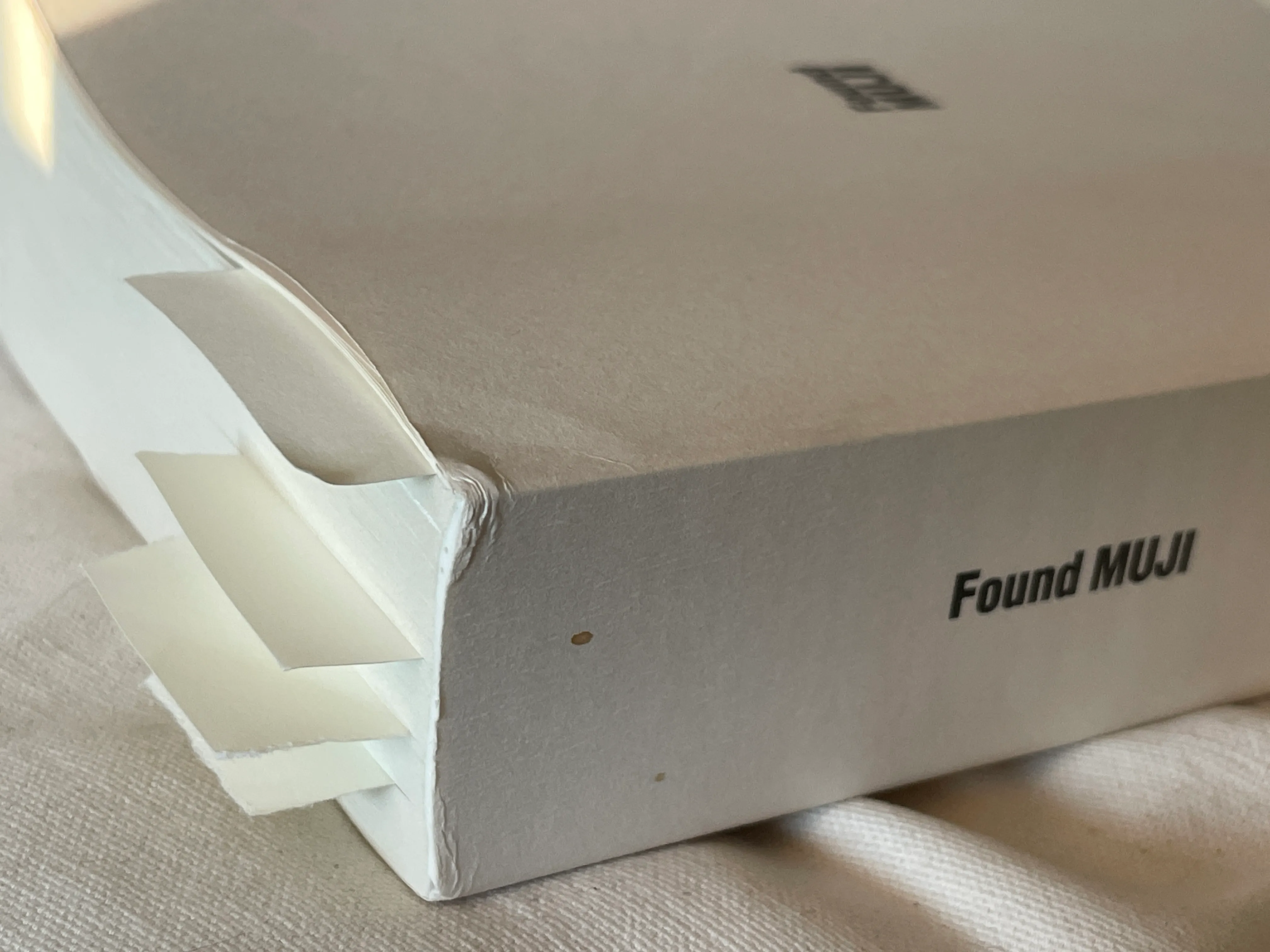 A photograph of the cover of Found Muji, with some bookmarks peeking out of the pages.